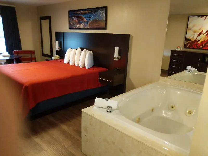 King bed beside a two-person jacuzzi tub in the King Jacuzzi Suite