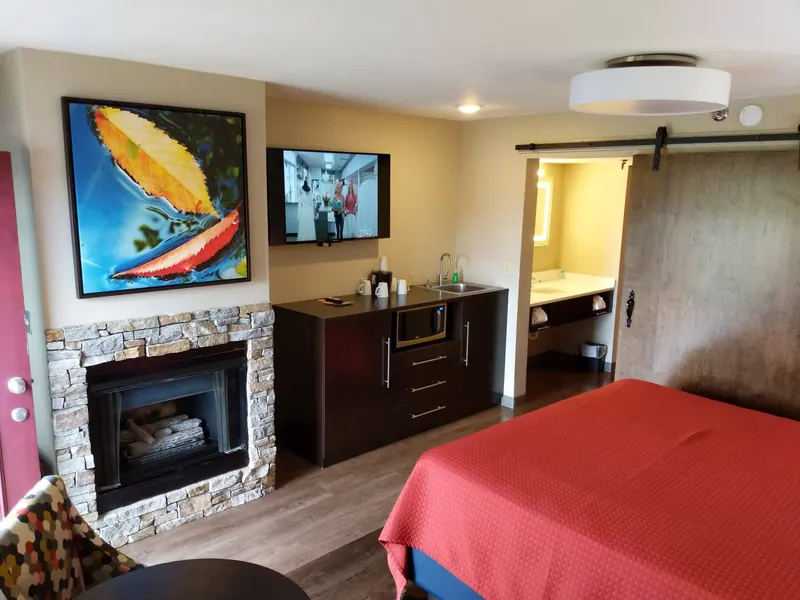 King suite with stone fireplace, flat-screen TV and red king bed